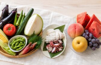 なす、トマト、オクラ、とうがん、たこ、いか、すいか、桃、ぶどう、梨を並べた8月の旬食材