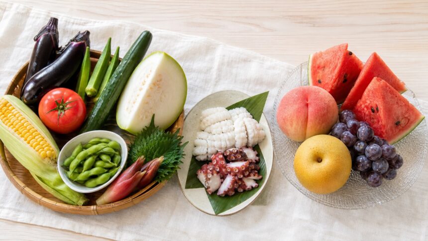 なす、トマト、オクラ、とうがん、たこ、いか、すいか、桃、ぶどう、梨を並べた8月の旬食材