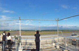 Panorama of the New Chitose Airport observation deck with visitors and runway views