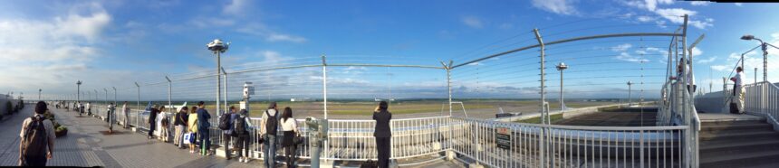 Panorama of the New Chitose Airport observation deck with visitors and runway views