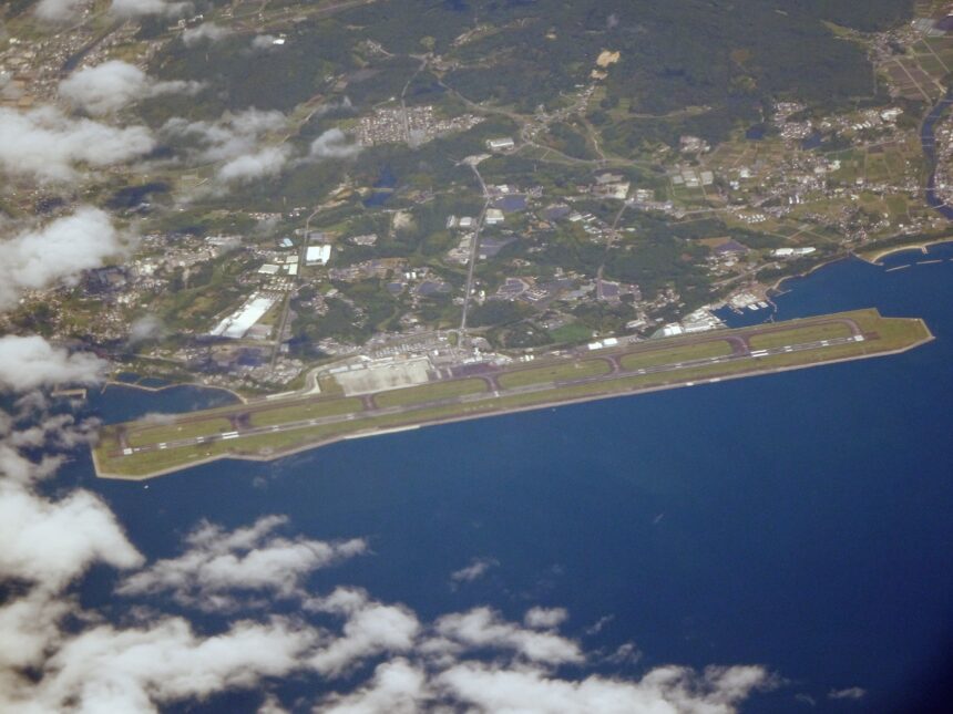 Aerial photograph of Oita Airport runway, terminal area, coastline, and sea