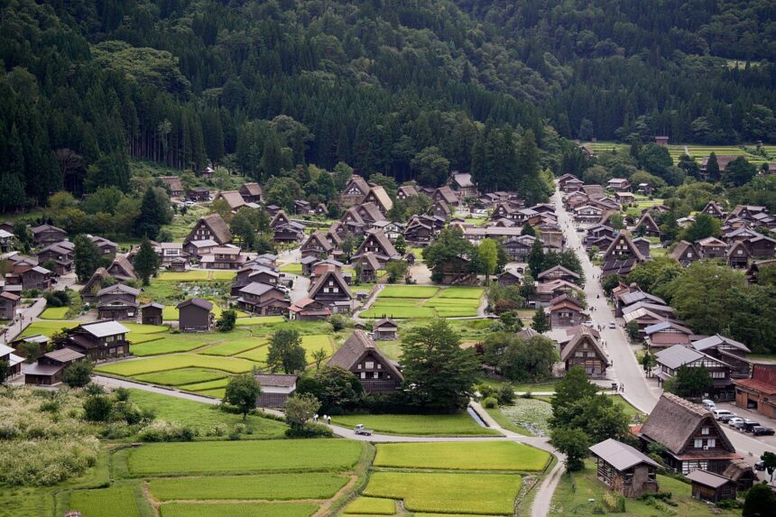 Aerial view of Shirakawa-go with gassho-zukuri farmhouses, rice paddies, and forested hills