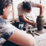Hands shaping clay on a pottery wheel during a workshop
