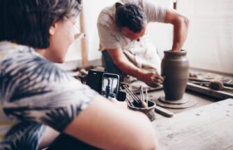 Hands shaping clay on a pottery wheel during a workshop