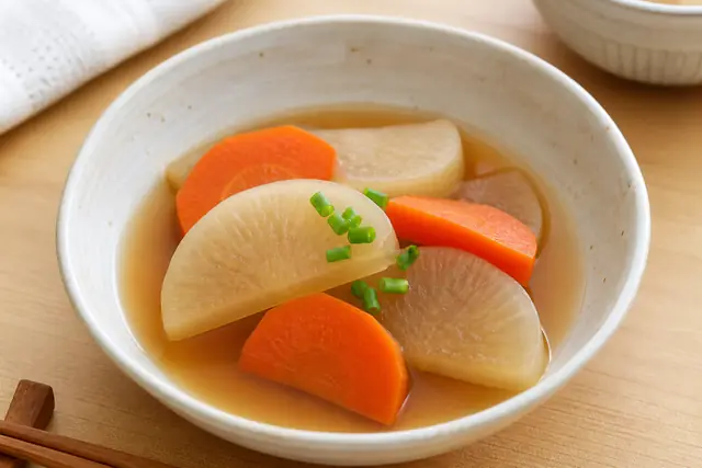 半月切りの大根とにんじんを煮た料理のイメージ