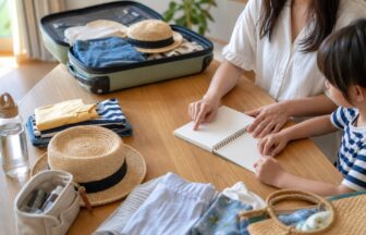 夏休み後半の旅行前に荷物と予定を家族で見直す様子