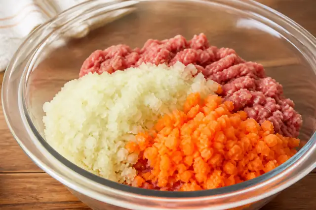 ひき肉に玉ねぎとにんじんのみじん切りを合わせたイメージ