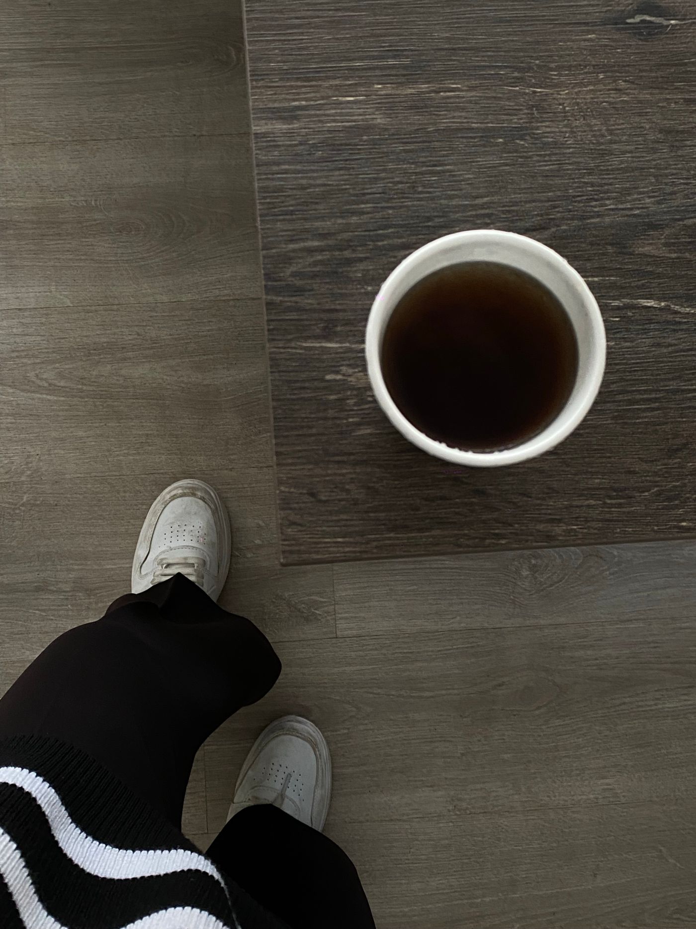木のテーブルに置かれたカフェのコーヒーカップ