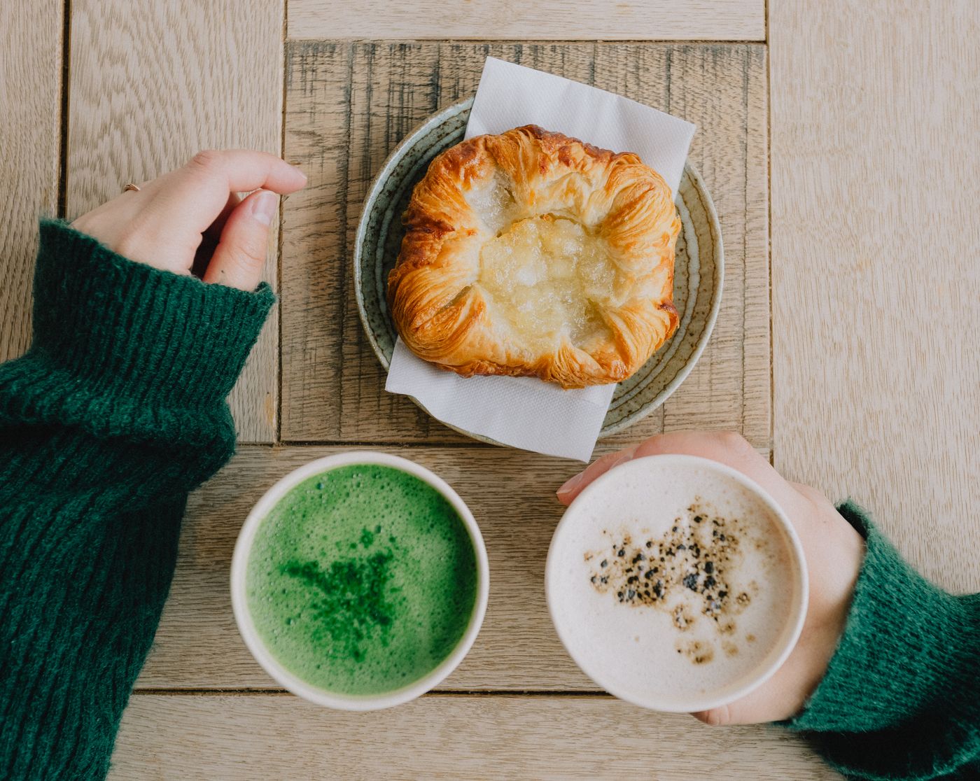 カフェのテーブルに置かれた抹茶ラテと焼き菓子