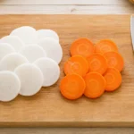 まな板の上に並べた大根とにんじんの輪切り