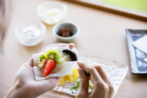 求肥に好みの果物を包む様子