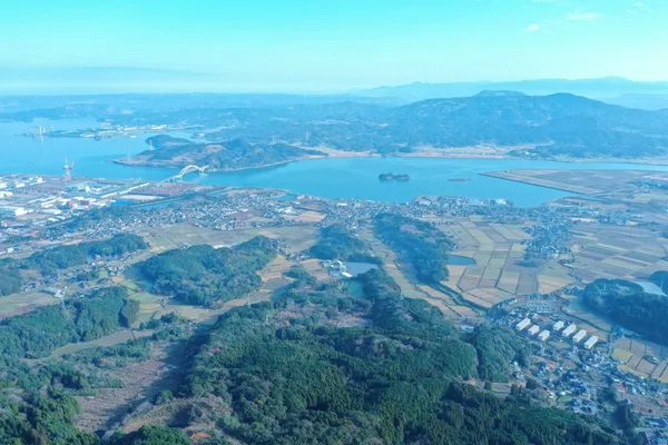 上空から見た伊万里湾。手前に田畑と集落、奥に湾と山並みが広がる