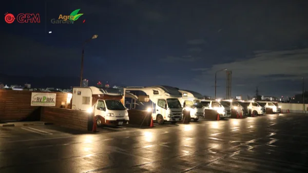 照明のついた区画にキャンピングカーが並ぶ夜のRVパーク