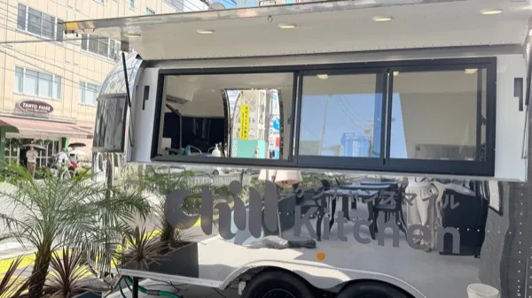 店名ロゴと販売窓がある銀色の移動販売車