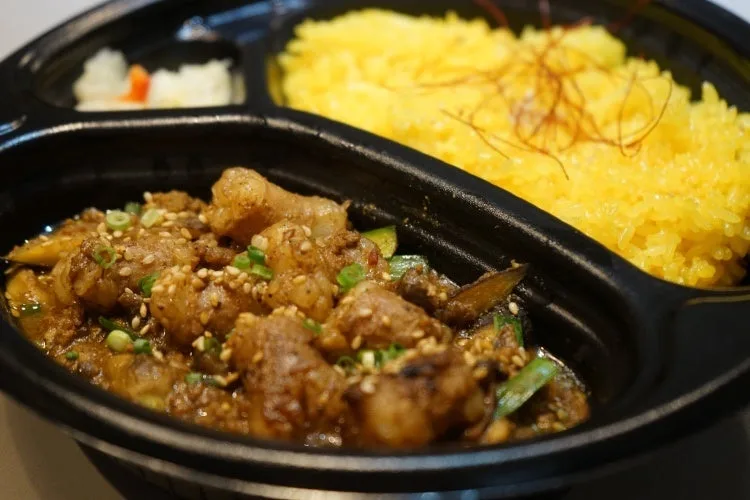 黒い容器に入った丸腸のキーマカレーと黄色いライス