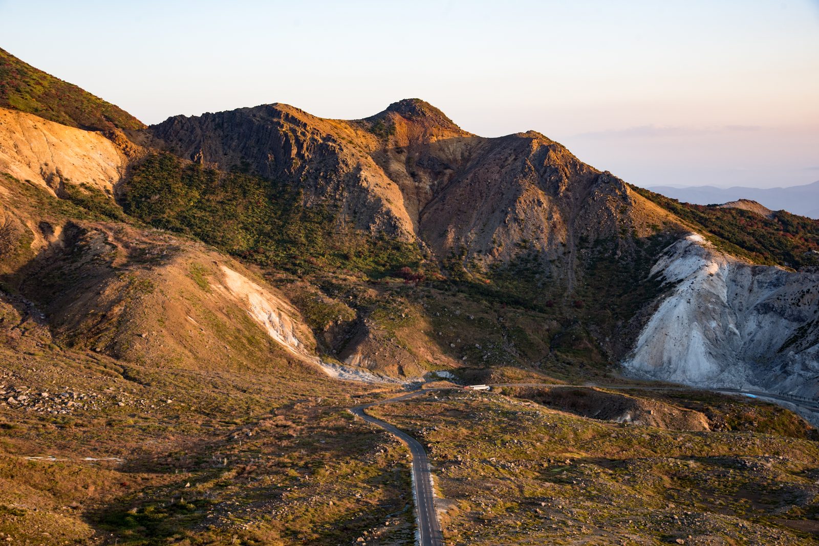 磐梯吾妻スカイラインの山岳道路。荒々しい火山の山肌の間を道が曲がりながら続く