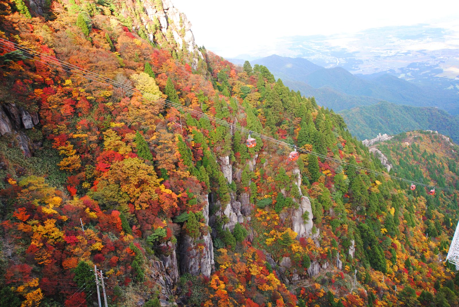 御在所岳の岩壁と紅葉。切り立った斜面が赤、橙、黄色に色づく