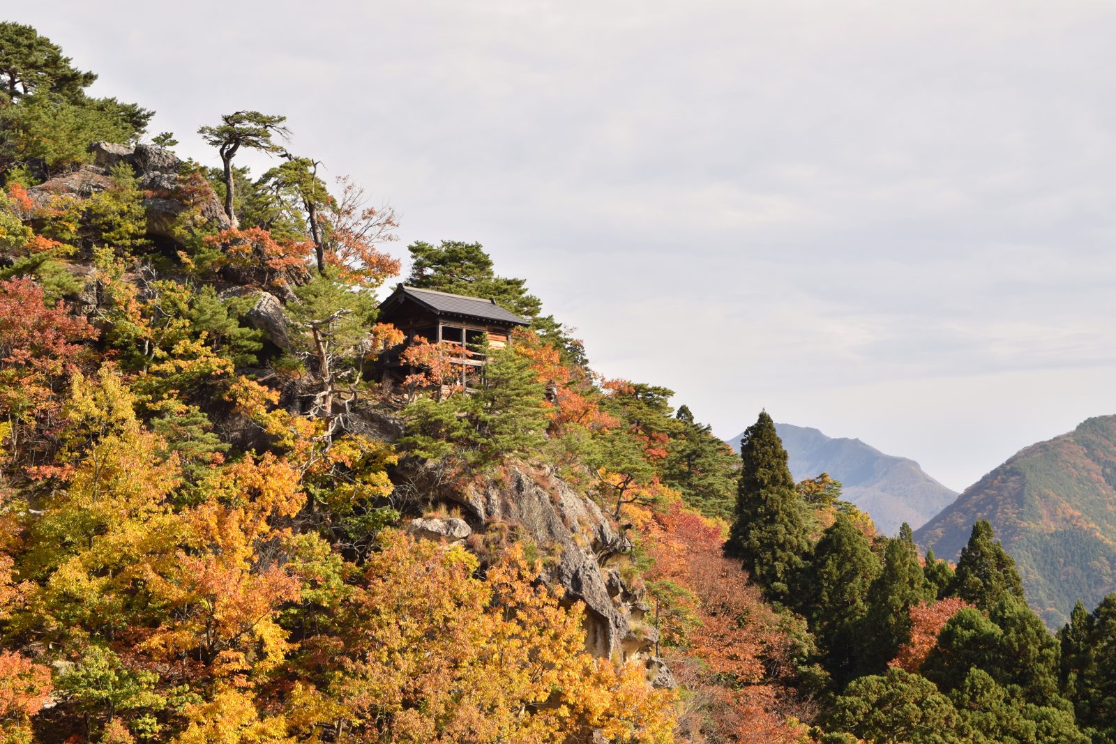 山寺（立石寺）の岩山と紅葉。岩の上のお堂の周りが赤や黄色に色づく