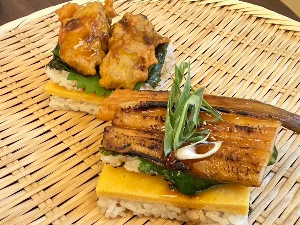 手前「炙り一本穴子」、奥「香味だれ牡蠣天むす」の『ごちそう焼むすび』