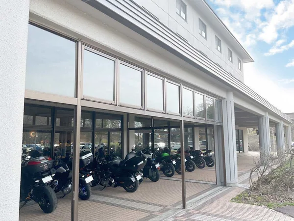 ガラス張りの建物の前にある屋根付きの駐車スペース