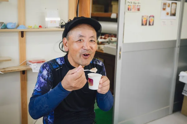 自分の畑のいちじくが入ったヨーグルトを口に運ぶ梶谷さん。