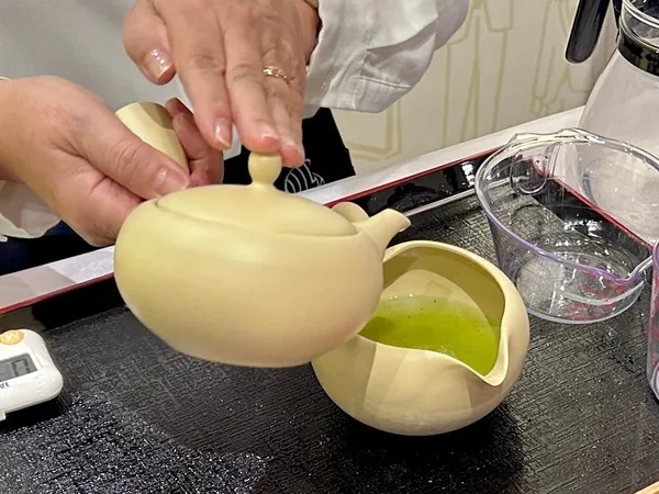 急須から複数の器へ日本茶を注ぐ様子