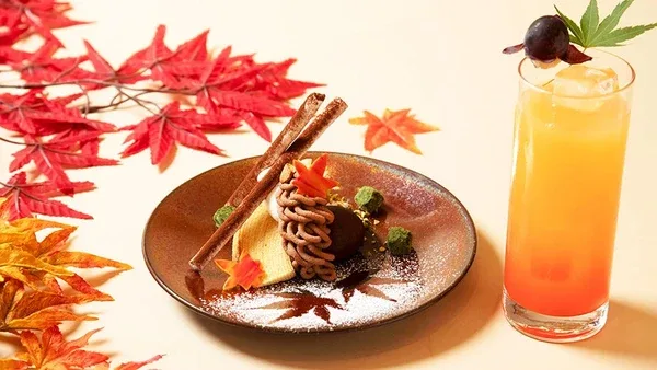 紅葉を添えた皿のバウムクーヘンとオレンジ色のドリンク
