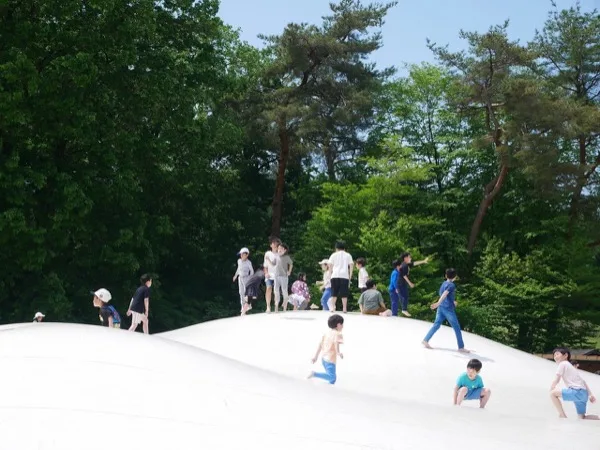 白い大型エアートランポリンの上で遊ぶ子どもたち