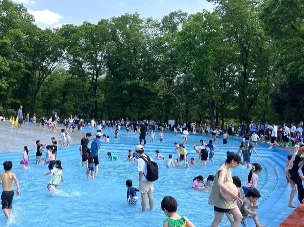 青い水遊び場に入る大勢の子どもと大人