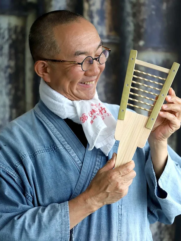 作務衣姿の作り手が、完成した鬼おろしを手に持って見せている