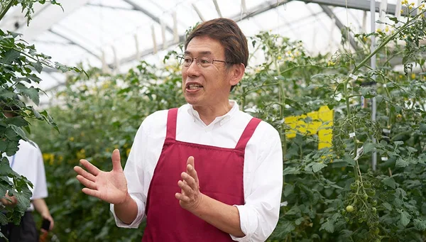見学者に説明をする生産者