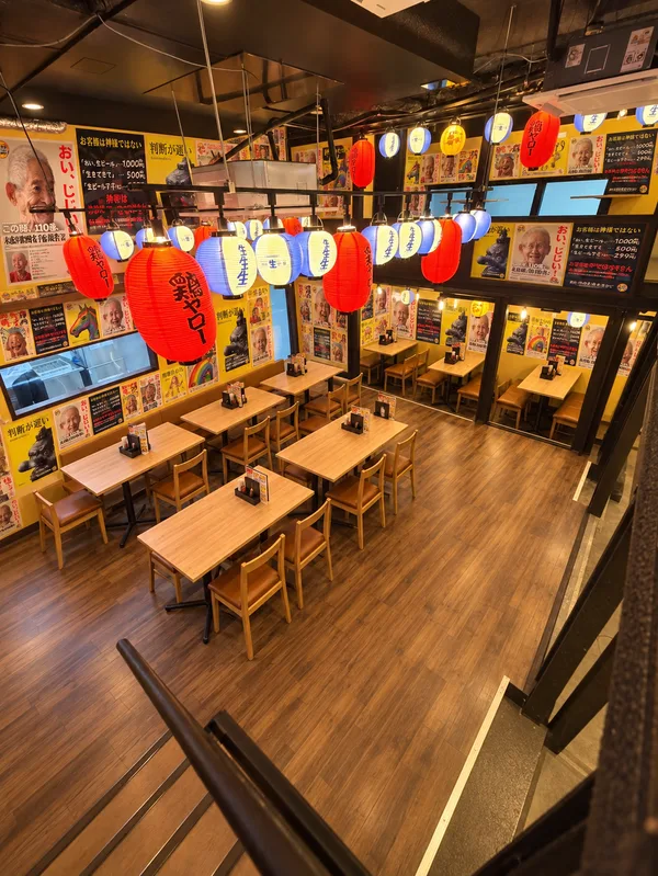 赤い提灯と木目のテーブルが並ぶ鶏ヤロー岡山店の店内